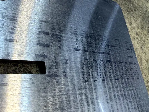 Edelstahlblech 5 mm nach Laserschnitt und Entgraten: die Werkskennzeichnung mit Werkstoff und Schmelznummer ist noch schwach sichtbar