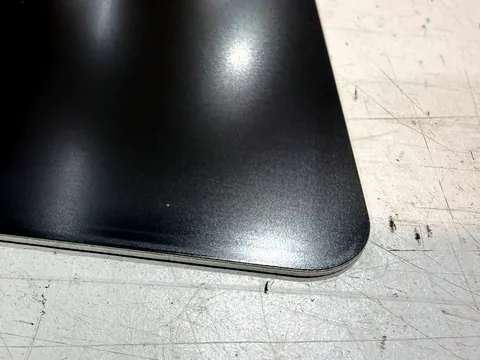 Gerade Kante und Radius eines anthrazit lackierten Aluminiumteils, ohne Schutzfolie gelasert
