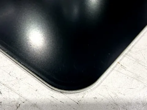 Gerundete Ecke eines anthrazit lackierten Aluminiumteils, ohne Schutzfolie gelasert